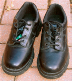 Une paire de chaussures de scurit  - Une paire de chaussures de scurit. On voit un triangle vert sur la languette.
