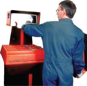 Un mécanicien devant une machine - Image d'un mécanicien en train de travailler. Il porte une combinaison bleue.
